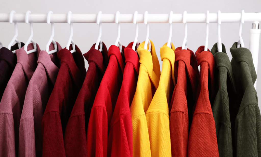 A selection of brightly colored clothes displayed on hangers
