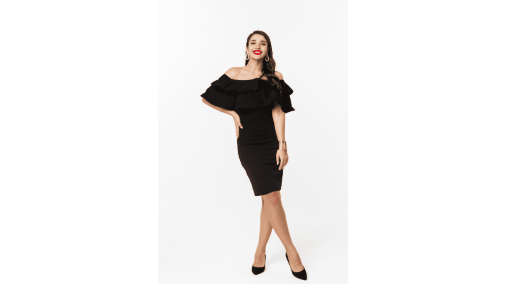 Timeless pieces showcased by a stunning brunette in a luxurious black dress and heels at a party, smiling with red lips, captured in a full-length shot against a white background - a beauty and fashion concept.