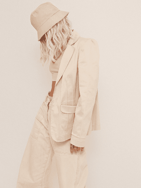 A photo of a blonde girl in urban street style, captured in a white studio with attention to everyday details.