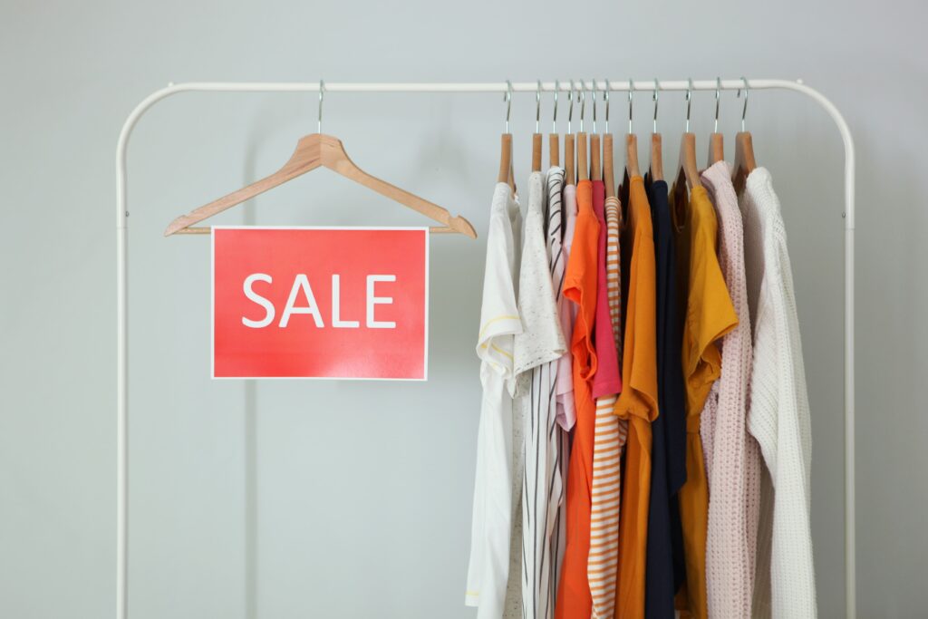 Image of clothes on a rail with a final sale discount sign, showcasing budget fashion deals.