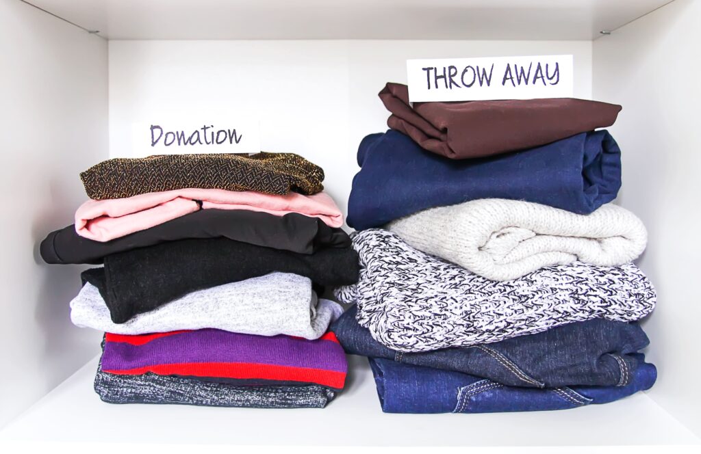 Clothes sorting in home wardrobe on white shelf background. donation, throw away paper notes.
