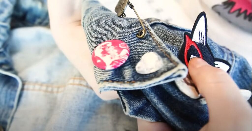 An image from a YouTube video showing a woman adding patches to an old garment.