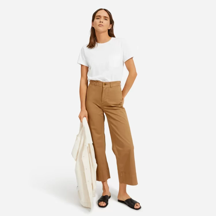 Woman dressed in a classic white tee paired with chic brown pants.