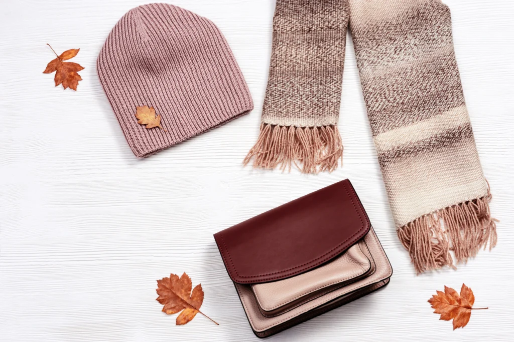 Photo autumn comfortable warm woolen scarf and cap and small woman leather bag and decorative leaves