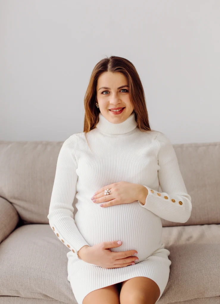 Elegant young pregnant woman modeling comfortable yet stylish dress appropriate for the workplace