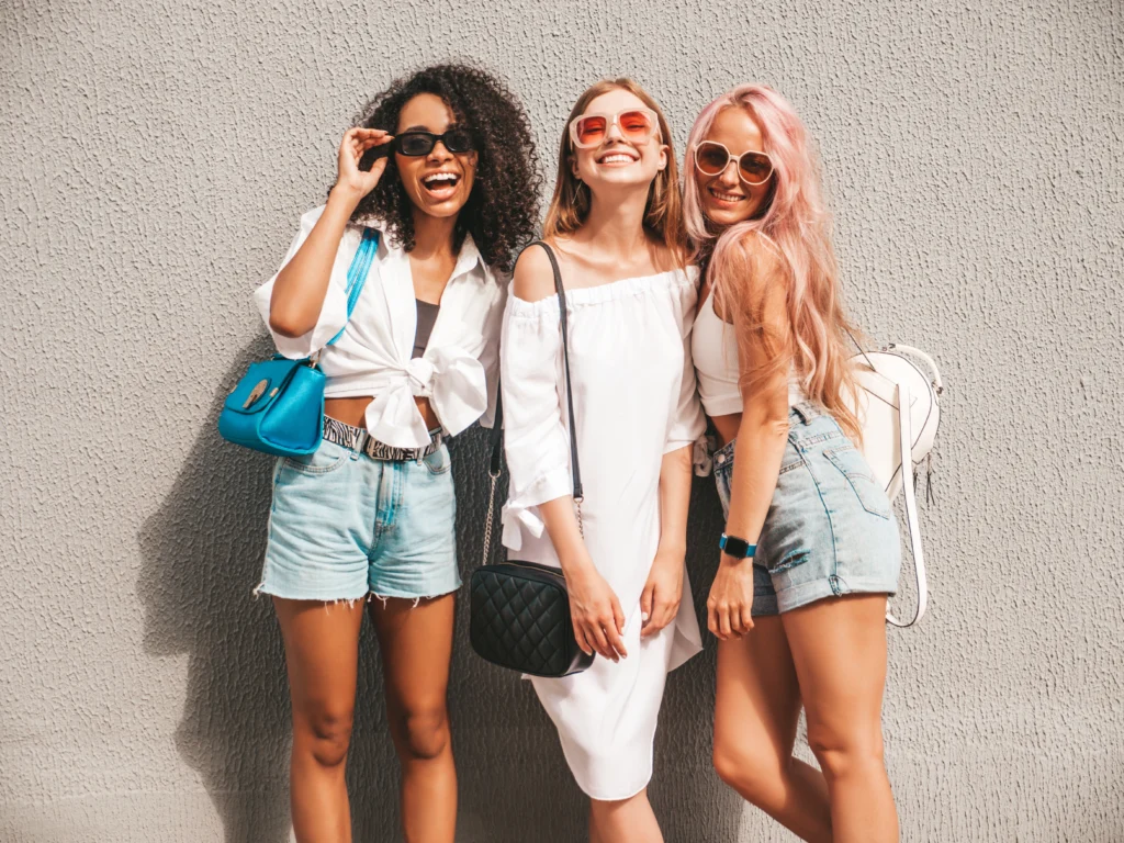 Free photo three young beautiful smiling female in trendy summer clothessexy carefree multiracial women posing on the street backgroundpositive models having fun in sunglasses cheerful and happy