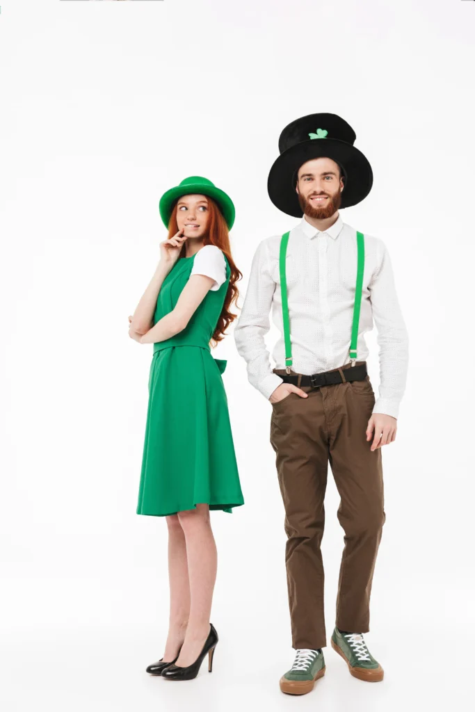 Photo full length of a happy young couple wearing costumes, celebrating stpatrick 's day isolated over white wall