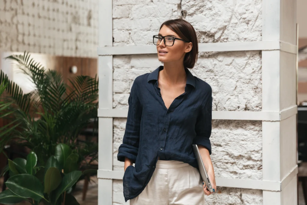 Vertical image of a female manager donning eyeglasses, showcasing a minimalist professional style.