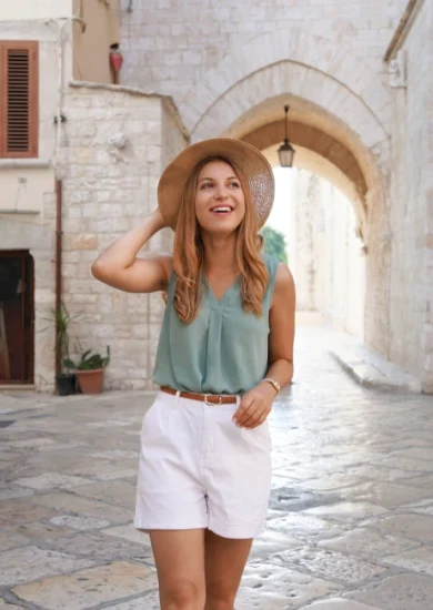 Vacation Outfit Ideas: Portrait of a Smiling, Attractive Tourist Woman Walking Alone in the City