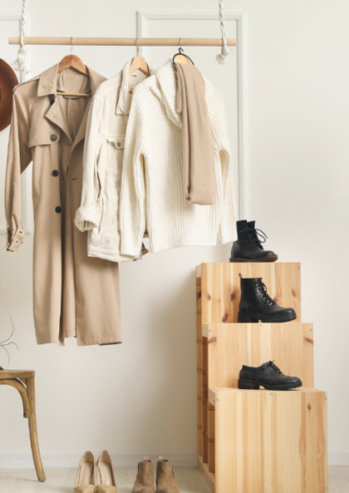 A wardrobe showcase featuring a trench coat, black boots, and fedora hats.